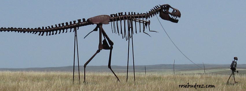 metal sculpture of a skeleton man leading a skeleton dinosauer.