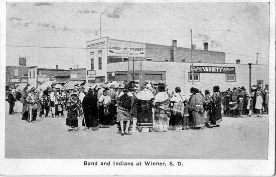 Postcard view of Indians dancing on Winner main street, circa 1930s.
