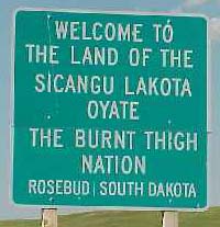 Highway sign: Welcome to the Land of the Sicangu Lakota Oyate the Burnt Thigh Nation. Rosebud, South Dakota.